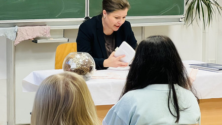 Ministerin Weidinger liest Schülern aus dem Buch "Das Versprechen" von Friedrich Dürrenmatt vor.