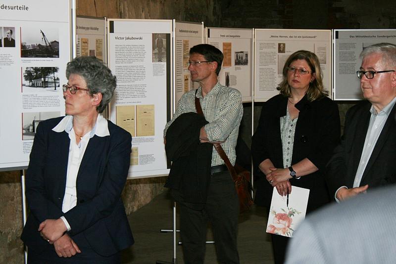 Ministerin Keding, Herr Thiel, Direktorin Braun und Oberbürgermeister Poschmann betrachten eine Tafel der Ausstellung